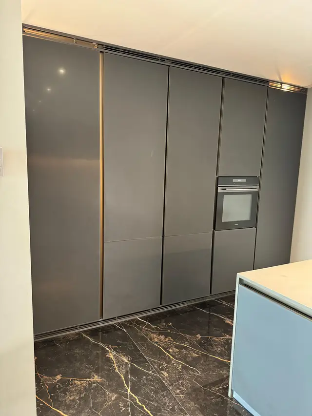 Full height grey tall storage wall in a modular kitchen