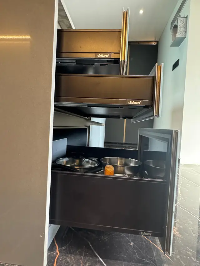 Open tandem drawers with internal organisers in a grey kitchen