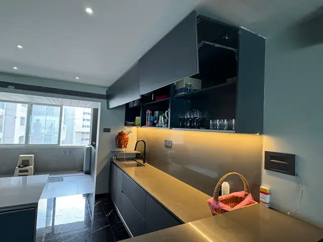 Dark modular kitchen with profile lighting over the worktop