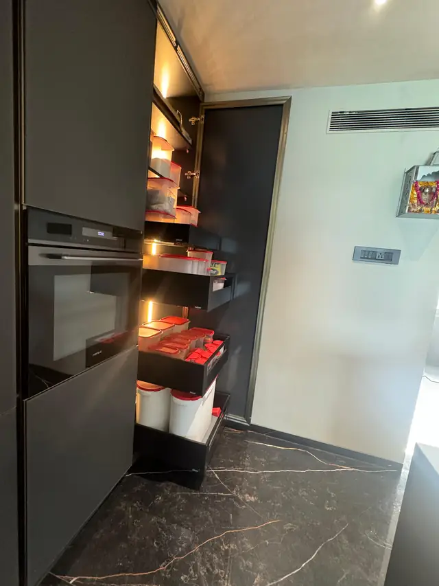 Dark pull-out pantry unit loaded with provisions