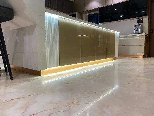Backlit gloss island counter in an open plan kitchen