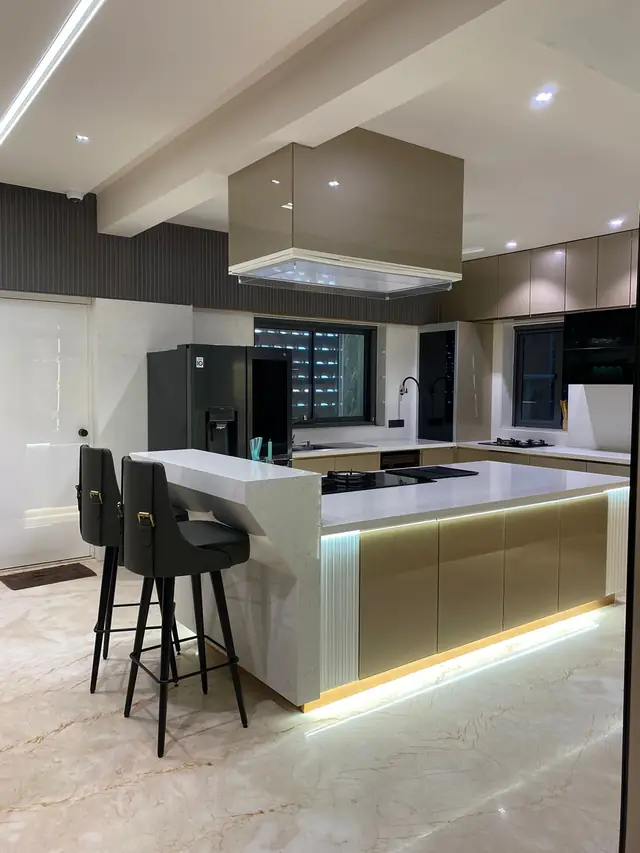 Open plan island kitchen with bar stools and false ceiling