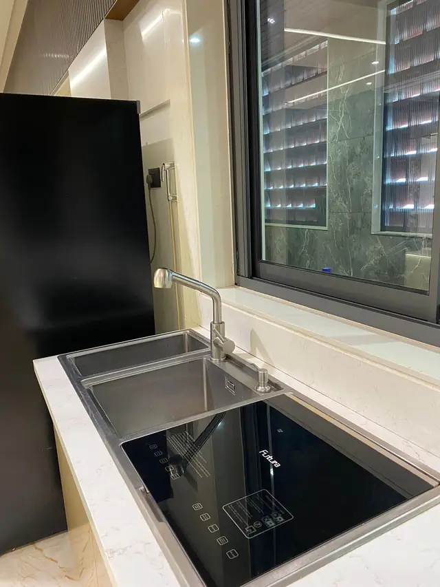 Sink and hob placed along a window in a modular kitchen