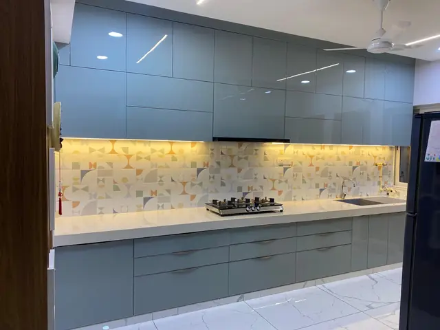 Grey modular kitchen with illuminated marble backsplash