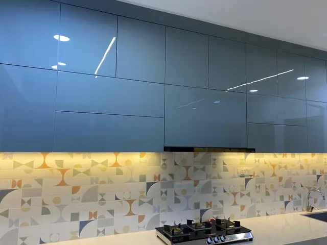 Blue grey kitchen with built-in hob and lit backsplash
