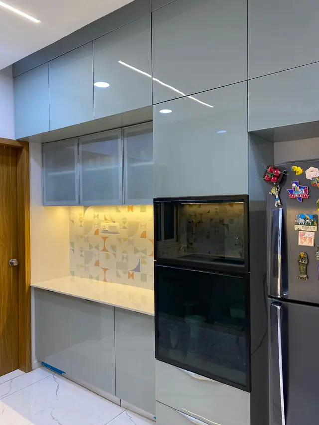 Grey modular kitchen with tall unit and refrigerator housing